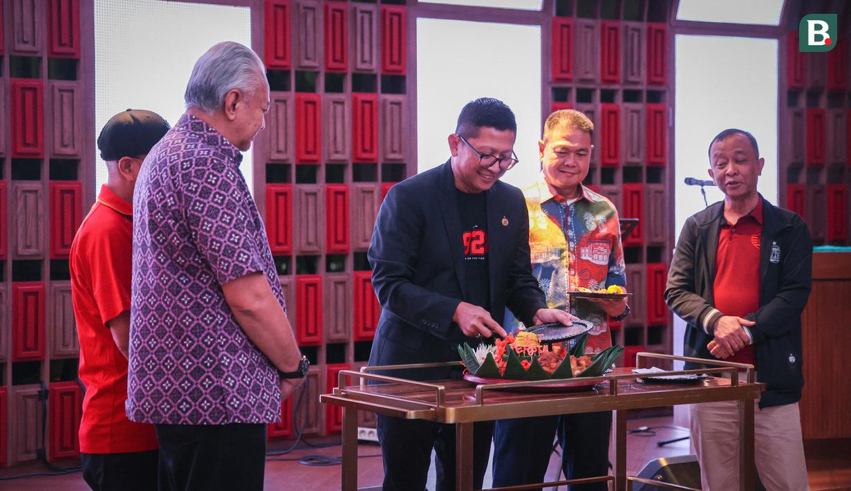 Pemotongan tumpeng yang dipimpin oleh Direktur Persija Jakarta, Mohamad Prapanca (tengah) yang akan diberikan simbolis pada acara perayaan Hari Ulang Tahun Persija ke-96 di Trinity Tower, Jakarta, Kamis (28/11/2024). (Bola.com/Abdul Aziz)