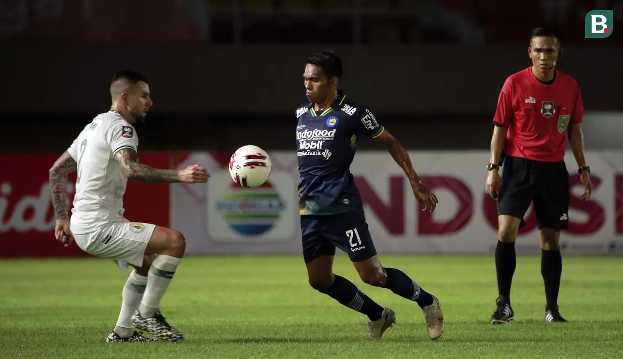 Pemain Persib Bandung, Frets Butuan (tengah) mengontrol bola dibayangi pemain PS Sleman, Aaron Michael Evans dalam laga leg kedua semifinal Piala Menpora 2021 di Stadion Manahan, Solo, Senin (19/4/2021). (Bola.com/Ikhwan Yanuar)
