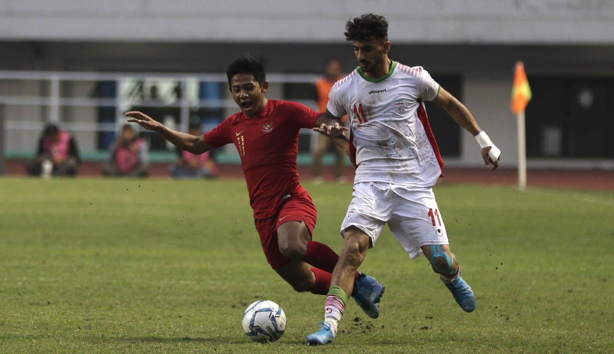 Bek Timnas Indonesia U-22, Firza Andika, berebut bola dengan pemain Timnas Iran U-23 pada laga uji coba internasional di Stadion Pakansari, Bogor, Sabtu (16/11). Indonesia menang 2-1 atas Iran. (Bola.com/Yoppy Renato)