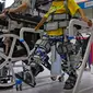 Seorang anak dan pengunjung lainnya mencoba kaki robot buatan yang digunakan untuk menopang penyandang disabilitas saat Konferensi Robot Dunia di Yichuang International Conference and Exhibition Centre, Beijing, China, 18 Agustus 2022. (AP Photo/Andy Wong)