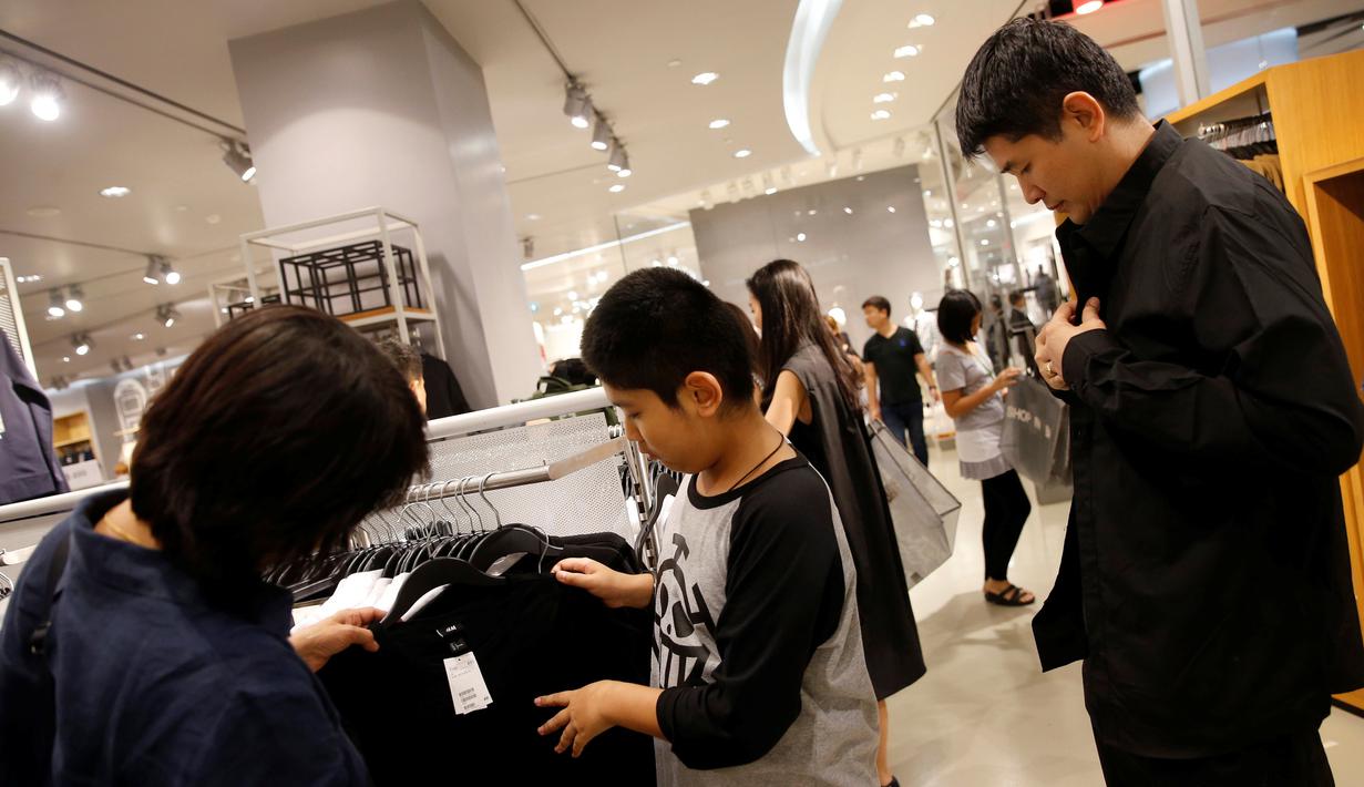 . Orang-orang berbelanja pakaian hitam atau putih untuk menghadiri penghormatan terakhir atas meninggalnya Raja Thailand Bhumibol Adulyadej di sebuah mall Bangkok, Thailand (15/10). (REUTERS / Edgar Su)