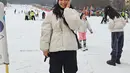 Bermain di salju, Hesti Purwadinata mengenakan puffer jacket putih, yang serasi dengan beanienya. Penampilannya semakin sempurna dengan cargo pants berwarna hitam. [Foto: Instagram/hestipurwadinata]