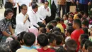 Presiden Joko Widodo (Jokowi) berdialog dengan para anak saat meninjau tenda pengungsian korban gempa Aceh di Pidie Jaya, Jumat (9/12). Dalam kunjungan tersebut, Jokowi membagikan buku tulis untuk anak-anak. (Liputan6.com/Angga Yuniar)