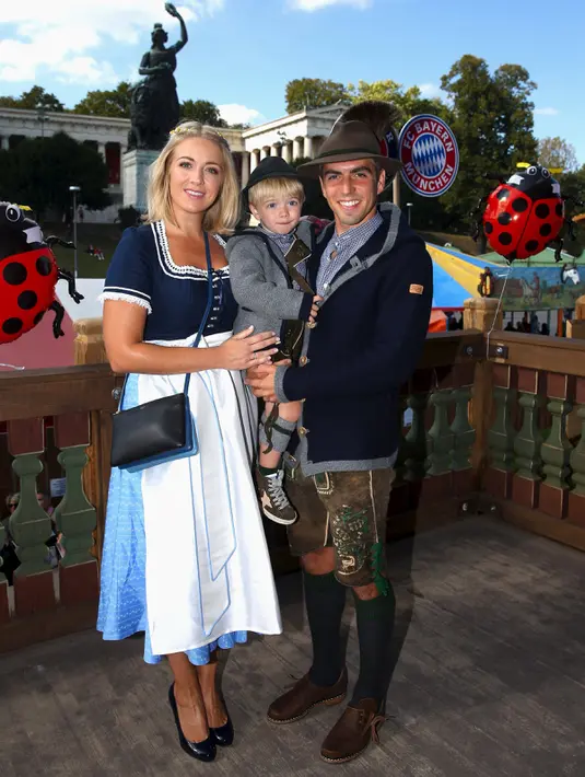 Pesepakbola tim Bayern Munchen, Philipp Lahm berpose bersama istrinya, Claudia serta anaknya saat menghadiri Festival Oktoberfest di Munich, Jerman, Rabu (30/9/2015). (REUTERS/Alexander Hassenstein/Pool)