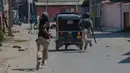 Tentara India berlindung di belakang bajaj saat mengejar warga Kashmir yang memprotes pembunuhan kelompok militan di Srinagar (4/1). Sebelumnya, 12 orang dari kelompok militan tewas saat bentrok dengan pasukan pemerintah India. (AP Photo / Dar Yasin)