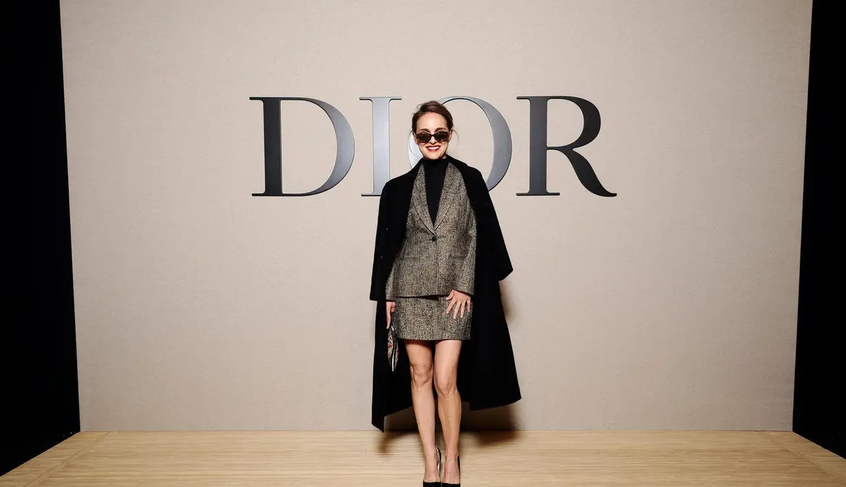 Natalie Portman curi perhatian dengan gaya lady boss. Ia kenakan setelan jas dan rok wool cokelat dengan turtleneck cashmere. Long coat wool hitam jadi sentuhan akhir pada penampilan mahal Natalie Portman [Dior]