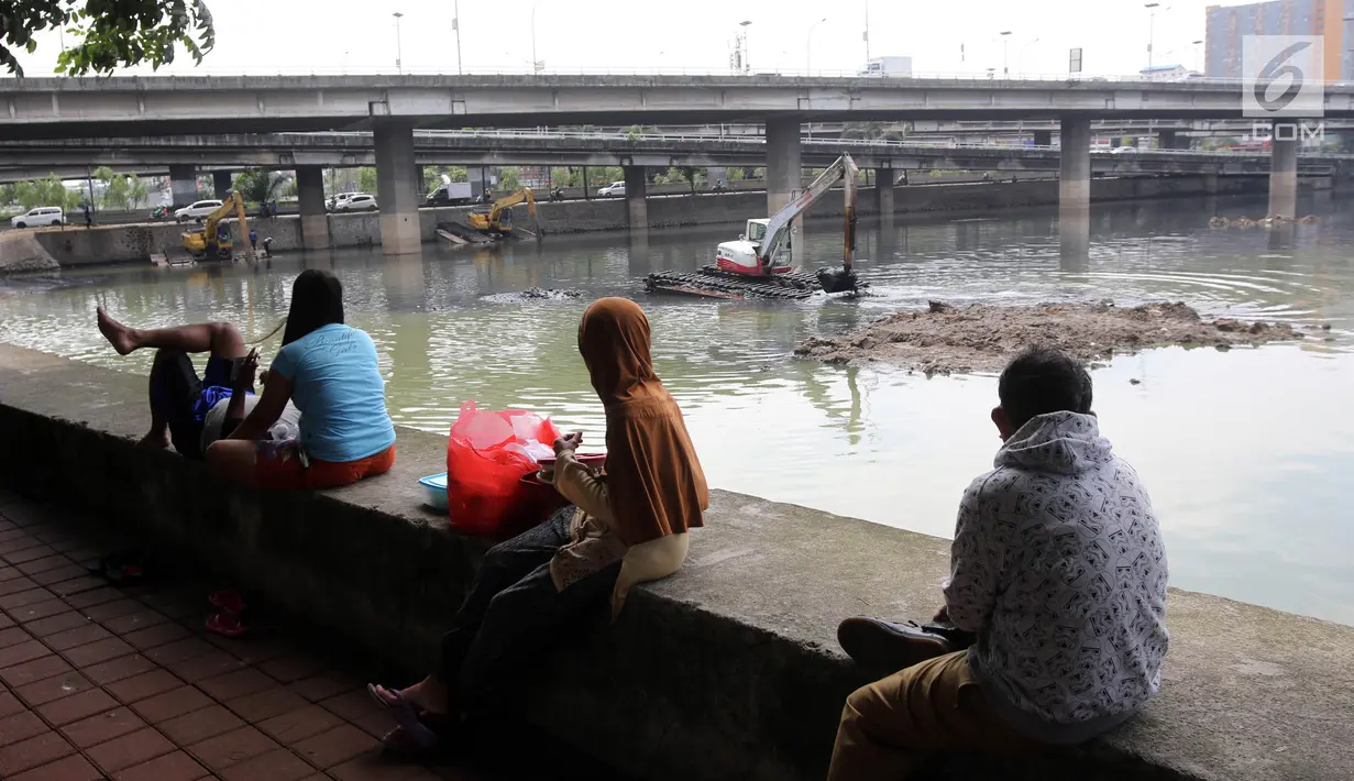 Warga menyaksikan proses pengerukan Waduk Grogol, Jakarta, Senin (9/4). Pengerukan dilakukan untuk mengatasi permasalahan banjir di Ibu Kota. (Liputan6.com/Arya Manggala)