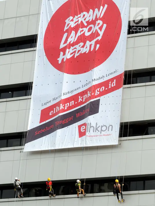 Aktivis membentangkan spanduk raksasa dengan cara repling turun dari gedung C Komisi Pemberantasan Korupsi (KPK) di Jakarta, Senin (26/3). (Merdeka.com/Dwi Narwoko)