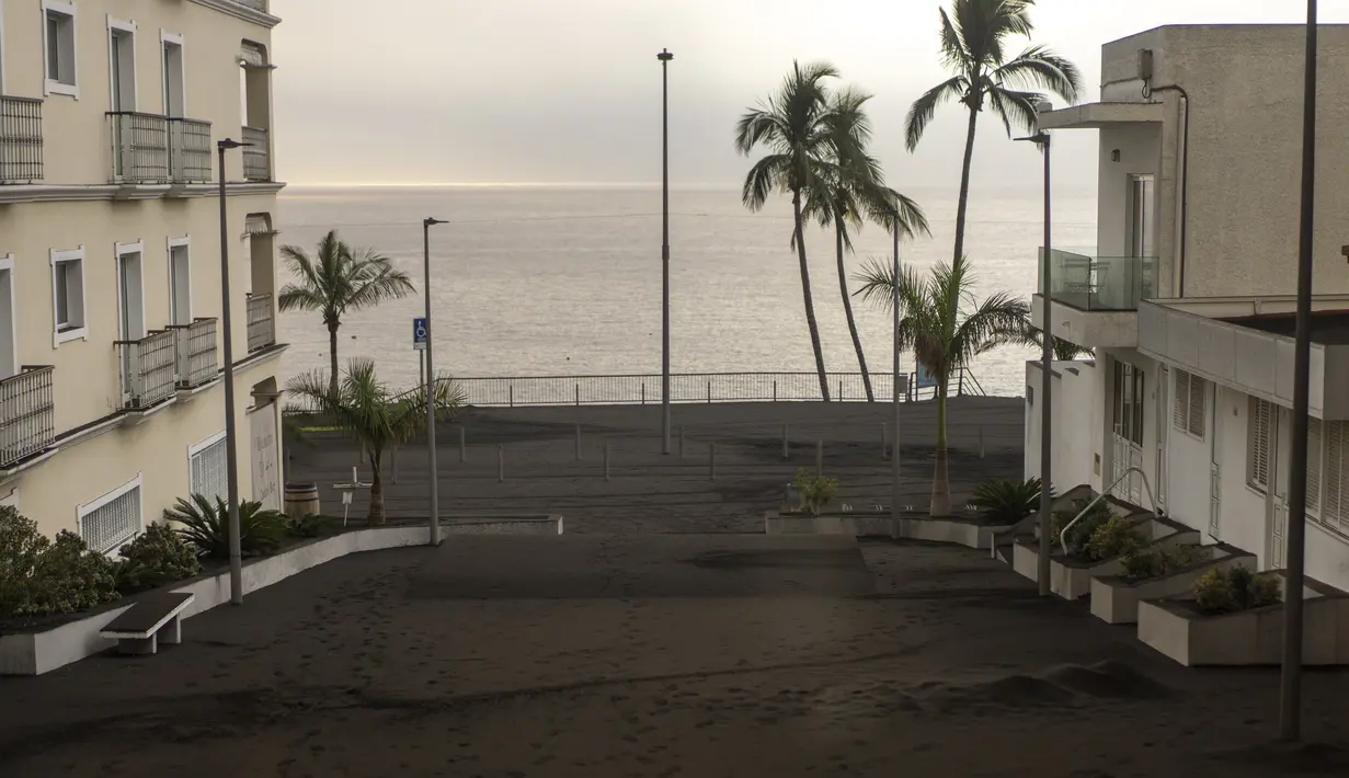 Abu gunung berapi Cumbre Vieja menutupi salah satu jalan desa Puerto Naos di pulau Canary La Palma, Spanyol, Rabu (27/10/2021). Penduduk di Pulau La Palma menghadapi kemungkinkan gempa yang lebih kuat yang bisa memperparah kerusakan oleh muntahan lava gunung tersebut. (AP Photo/Emilio Morenatti)