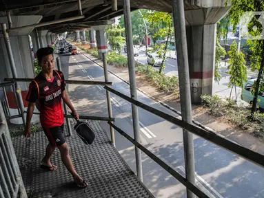 Pejalan kaki melintas di jembatan penyeberangan orang (JPO) halte transjakarta Bea Cukai di Jalan Ahmad Yani, Jatinegara, Jakarta, Kamis (5/12/2019). Sementara ini JPO hanya dipasang besi seadanya sebagai pengaman untuk para pengguna yang melintasi jembatan tersebut. (Liputan6.com/Faizal Fanani)