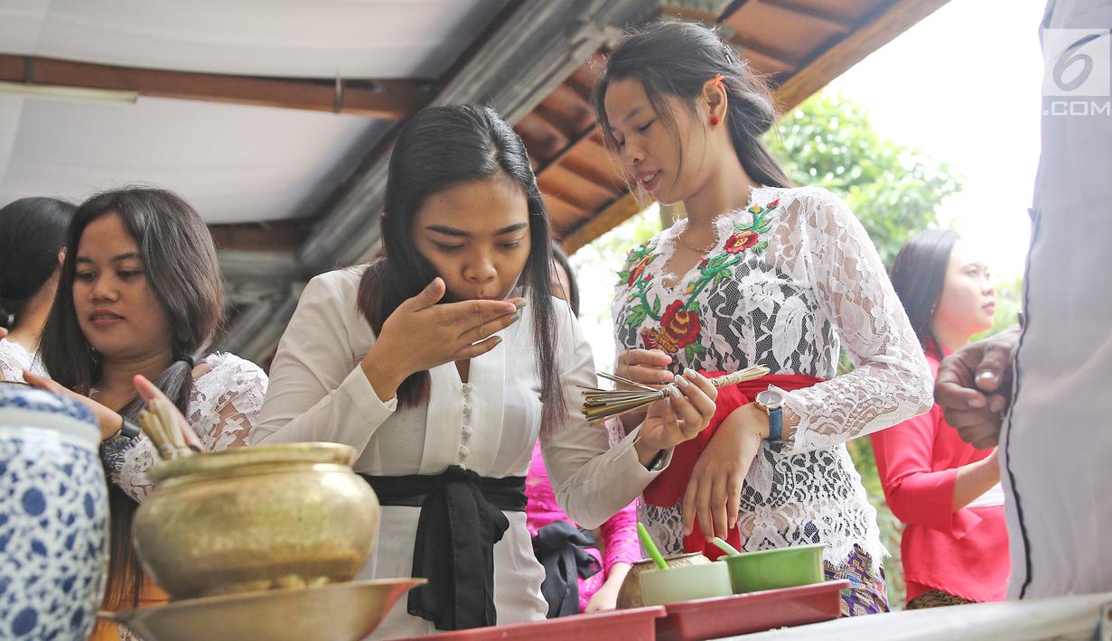 Umat Hindu meminum air suci seusai sembahyang di Pura Aditya Jaya, Jakarta, Sabtu (17/3). Sembahyang tersebut dilakukan untuk perayaan Hari Raya Nyepi Tahun Baru Saka 1940. (Liputan6.com/Herman Zakharia)