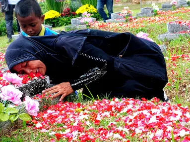Keluarga korban Tragedi Mei 98 memeluk nisan makam sanak famili mereka yang menjadi korban Tragedi Mei 98 di TPU Pondok Ranggon, Jakarta Timur, Rabu (13/5/2015). (Liputan6.com/Yoppy Renato)