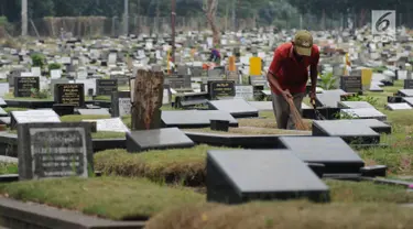 Petugas membersihkan makam di TPU Tanah Kusir, Jakarta, Selasa (29/8). Suku Dinas Kehutanan DKI Jakarta berencana memperluas area TPU Tanah Kusir sebesar 1,9 hektare. (Liputan6.com/Helmi Fithriansyah)