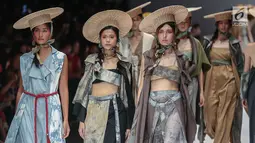 Model memperagakan busana rancangan HUMBANG SHIBORI x PURANA saat Jakarta Fashion Week 2019 di Senayan City, Jakarta, Kamis (25/10). Tenun ikat Humbang Shibori merupakan kerajinan kriya yang dibuat dengan metode ikat celup. (Liputan6.com/Faizal Fanani)