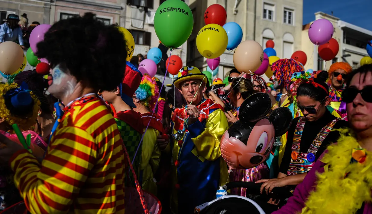 Orang-orang yang mengenakan pakaian badut ikut serta dalam parade badut tahunan di Sesimbra, Portugal pada Senin (4/3/2019). Perayaan ini dilakukan setiap tahun dan jatuh pada hari Senin. (PATRICIA DE MELO MOREIRA / AFP)