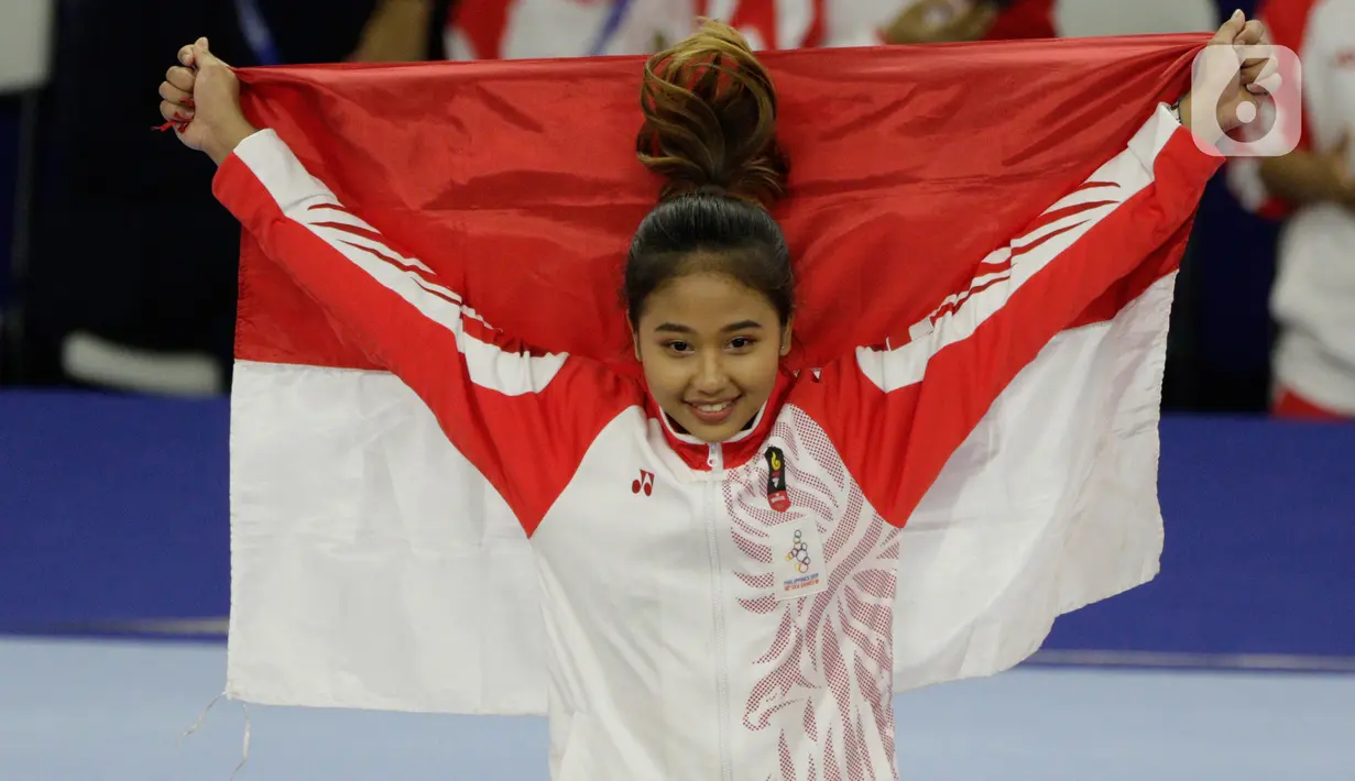 Pesenam Indonesia, Rifda Irfanaluthfi, berpose dengan bendera Merah Putih usai pertandingan Senam Artistik SEA Games 2019 di Kompleks Rizal Memorial, Manila, Senin (2/12/2019). Rifda Irfanaluthfi berhasil meraih medali dari nomor all-round individual putri cabang senam. (Bola.com/M Iqbal Ichsan)