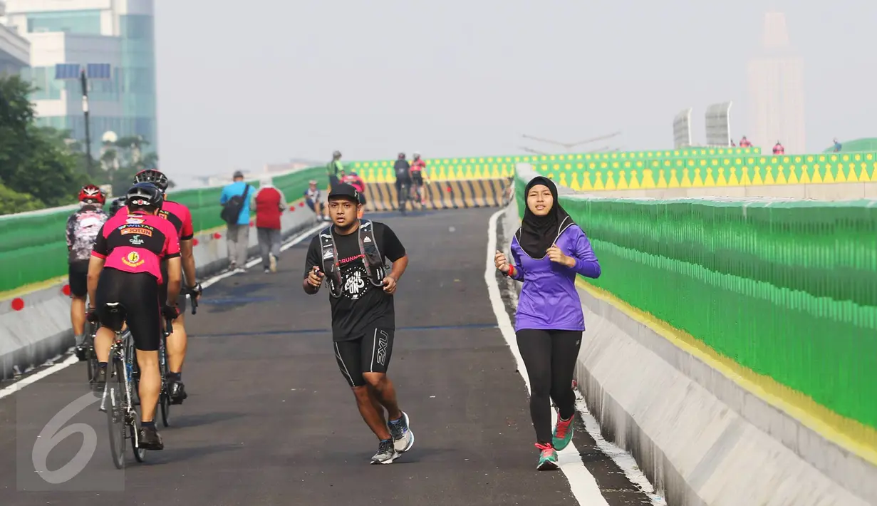 Warga bersepeda dan berlari di sepanjang jalan layang (elevated) Transjakarta rute Cileduk-Tendean di Jakarta, Minggu (26/2). (Liputan6.com/Immanuel Antonius)
