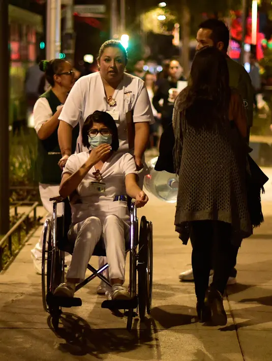 Seorang pasien dievakuasi dari sebuah rumah sakit saat terjadi gempa kuat di Mexico City, Meksiko (16/2). Di Mexico City, gedung-gedung bertingkat bergoyang selama lebih dari semenit akibat gempa ini. (AFP Photo/Pedro Pardo)