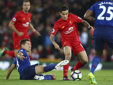Pemain Liverpool,  Philippe Coutinho, (tengah) mencoba melewati hadangan dua pemain Manchester United pada lanjutan Premier League di Anfield stadium, Liverpool, Selasa (18/10/2016) dini hari WIB. (AP/Dave Thompson)