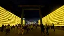 Sejumlah pengunjung melihat lentera yang memeriahkan Festival Mitama di Kuil Yasukuni, Tokyo, Jepang, (13/7). Sekitar 30.000 lentera menerangi daerah terseubt untuk mengenang korban perang.  (AFP Photo/Toru Yamanka)