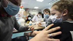 Anak-anak disuntik vaksin covid-19 di pusat vaksinasi di Selestat, Prancis, Selasa (21/12/2021). Pemerintah Prancis meningkatkan upaya vaksinasi di tengah infeksi yang berkembang pesat oleh varian omicron, terutama membuka suntikan untuk anak di bawah 12 tahun. (AP Photo/Jean-Francois Badias)