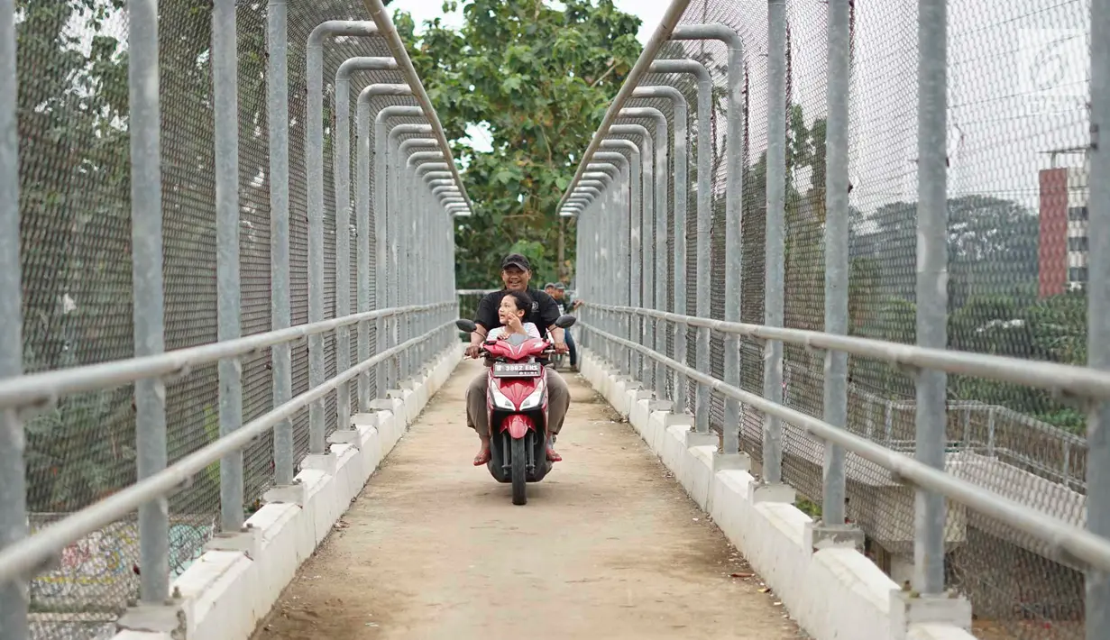 Pengendara sepeda motor terjatuh saat melintasi JPO yang melintang di atas Tol Cijago Seksi II di Depok, Jawa Barat, Rabu (15/5). Meskipun berbahaya, namun curamnya akses JPO tidak menjadi penghalang bagi pemotor untuk menyeberang agar memersingkat waktu tempuh. (Liputan6.com/immanuel Antonius)