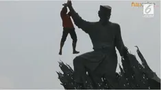 Seorang pria melakukan aksi tak wajar di atas patung Zapin yang berada di kawasan pusat kota Pekanbaru.