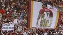 Supporter membawa bendera raksasa bergambar Francesco Totti saat laga terakhir sang legenda di Stadion Olimpico, Roma, Minggu (28/5/2017). Selama 25 tahun Totti berkarier di AS Roma. (AP/Alessandra Tarantino)