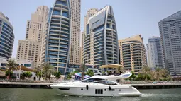 Sebuah kapal pesiar mewah terlihat di Dubai Marina Beach, emirat Teluk pada 10 Juni 2021. Di tengah aturan pandemi di mana warga harus menjaga jarak dan menghindari keramaian, orang-orang kaya di Dubai memiliki cara untuk bisa pergi berekreasi, yaitu mode wisata kapal pesiar. (Karim SAHIB/AFP)