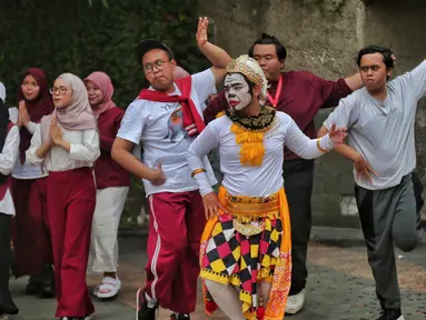 Sejumlah mahasiswa melakukan paduan suara dan gerak tari saat Car Free Day, di Jakarta, Minggu (25/9/2022). Pagelaran ini merupakan bentuk pengenalan seni kepada masyarakat yang tengah melakukan aktivitas di CFD. (Liputan6.com/Angga Yuniar)
