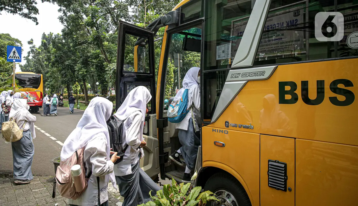 Pelajar menaiki bus sekolah usai pembelajaran tatap muka (PTM) di SMK Negeri 15, Kebayoran Baru, Jakarta Selatan, Jumat (3/9/2021). Dishub DKI Jakarta melalui Unit Pengelola Angkutan Sekolah membantu sarana transportasi gratis bagi peserta didik yang mengikuti PTM. (Liputan6.com/Faizal Fanani)