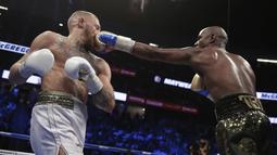 Pukulan jabs Floyd Mayweather Jr. mendarat wajah kanan Conor McGregor pada gelaran Tinju Dunia super welterweight boxing di MGM Arena, Las Vegas, (26/8/2017). Mayweather menang TKO atas McGregor. (AP/Isaac Brekken)