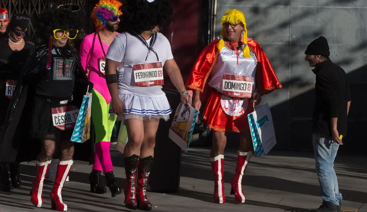 Sejumlah peserta tiba untuk mengikuti balapan high heels pria di Madrid, Spanyol (18/1). Para pria ini mengenakan kostum dan sepatu hak tinggi layaknya wanita. (AP Photo / Paul White)