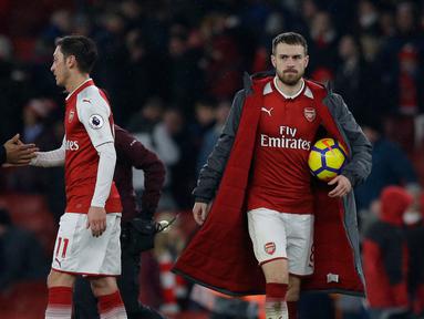 Pemain Arsenal Aaron Ramsey (kanan) membawa bola usai pertandingan melawan Everton dalam Liga Inggris di Stadion Emirates, London (3/2). Dalam pertandingan ini Aaron Ramsey berhasil menyumbang tiga gol untuk Arsenal. (AP Photo / Alastair Grant)