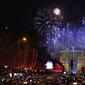 Sejumlah warga memotret kembang api di atas Arc de Triomphe ketika mereka merayakan Tahun Baru di Champs Elysees, di Paris, Prancis, Rabu (1/1/2019). (AP Photo / Christophe Ena)