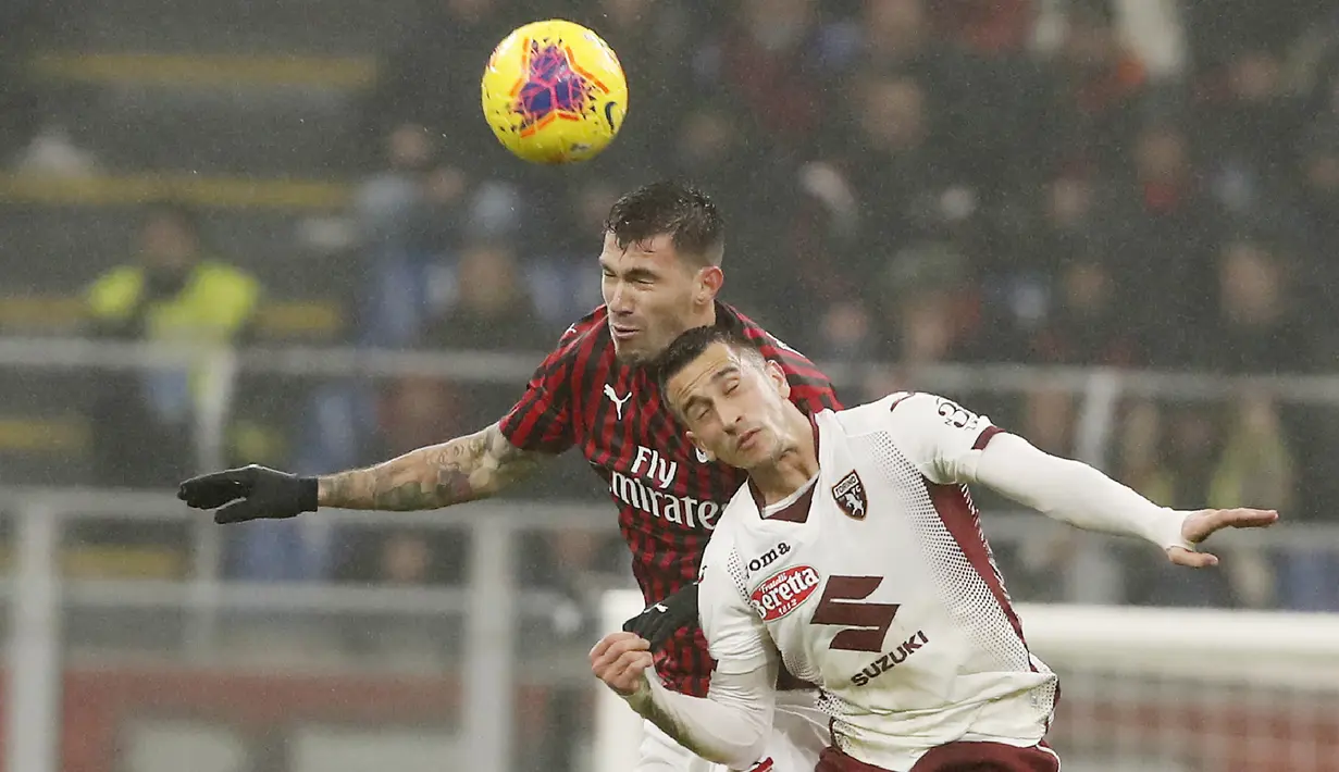 Bek AC Milan, Alessio Romagnoli (kiri) berebut bola udara dengan penyerang Torino, Alex Berenguer pada pertandingan lanjutan Liga Serie A Italia di stadion San Siro, di Milan, Italia, (18/2/2020). Milan menang tipis atas Torino 1-0. (AP Photo/Antonio Calanni)