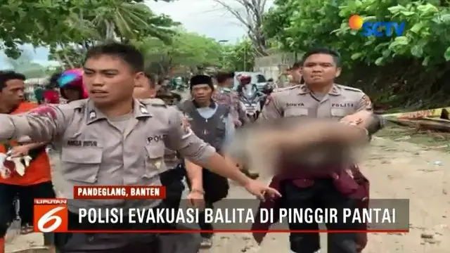 Petugas gabungan evakuasi bocah laki-laki korban tsunami Anyer di pinggir Pantai Karang Bolong. Saat ditemukan, bocah tersebut dalam keadaan tanpa busana dan tampak lemas.