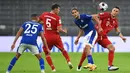 Bek Bayern Munchen, Benjamin Pavard, berebut bola dengan pemain Schalke pada laga Liga Jerman di Allianz Arena, Sabtu (19/9/2020) dini hari WIB. Bayern Munchen menang 8-0 atas Schalke. (AFP/Christof Stache)