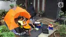 Aktivitas warga saat work from home di halaman rumahnya di kawasan Cinere, Depok, Senin (23/3/2020). Imbauan pemerintah untuk bekerja dari rumah atau work from home untuk mencegah penularan virus corona, dimanfaatkan warga dengan beragam aktivitas. (merdeka.com/Arie Basuki)