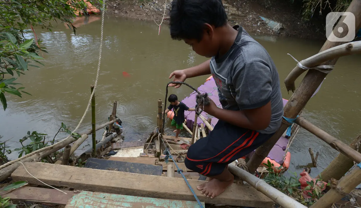 Anak-anak usai menggunakan perahu eretan di sungai Ciliwung, Jakarta, Selasa (3/11/2020). Perahu eretan di sungai Ciliwung masih bertahan sebagai penghubung Jakarta Timur dan Jakarta Selatan Selatan. (merdeka.com/Imam Buhori)