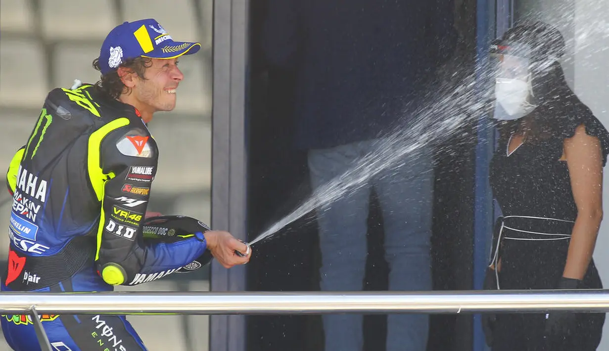 Pembalap Monster Yamaha, Valentino Rossi, merayakan kemenangan di atas podium usai menjuarai MotoGP Andalusia di Sirkuit Jerez, Minggu (26/7/2020). Fabio Quartararo berhasil finis pertama dengan catatan waktu 41 menit 22,666 detik. (AP Photo/David Clares)