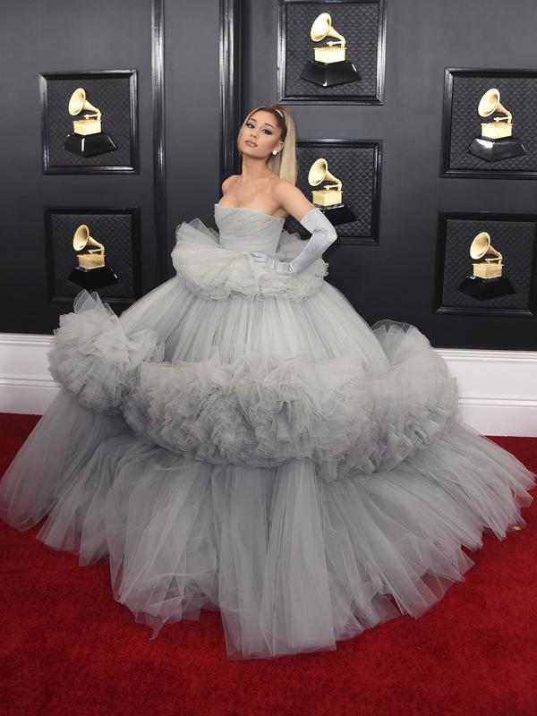Ariana Grande berpose di karpet merah saat tiba menghadiri Grammy Awards ke-62 di Staples Center di Los Angeles (26/1/2020). Penampilan Ariana Grande dengan gaun bernuansa abu-abu yang menawan ini berhasil menuai banyak pujian. (AP Photo/Jordan Strauss)