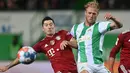 Gelandang Greuther Fuerth Sebastian Griesbeck dan penyerang Bayern Munchen Robert Lewandowski berebut bola pada pekan keenam Liga Jerman 2021/2022 di Trolli Arena, Sabtu (25/9/2021) dini hari WIB. Die Roten –julukan Bayern Munchen – menang 3-1 atas tim promosi Greuther Furth. (Christof STACHE/AFP)