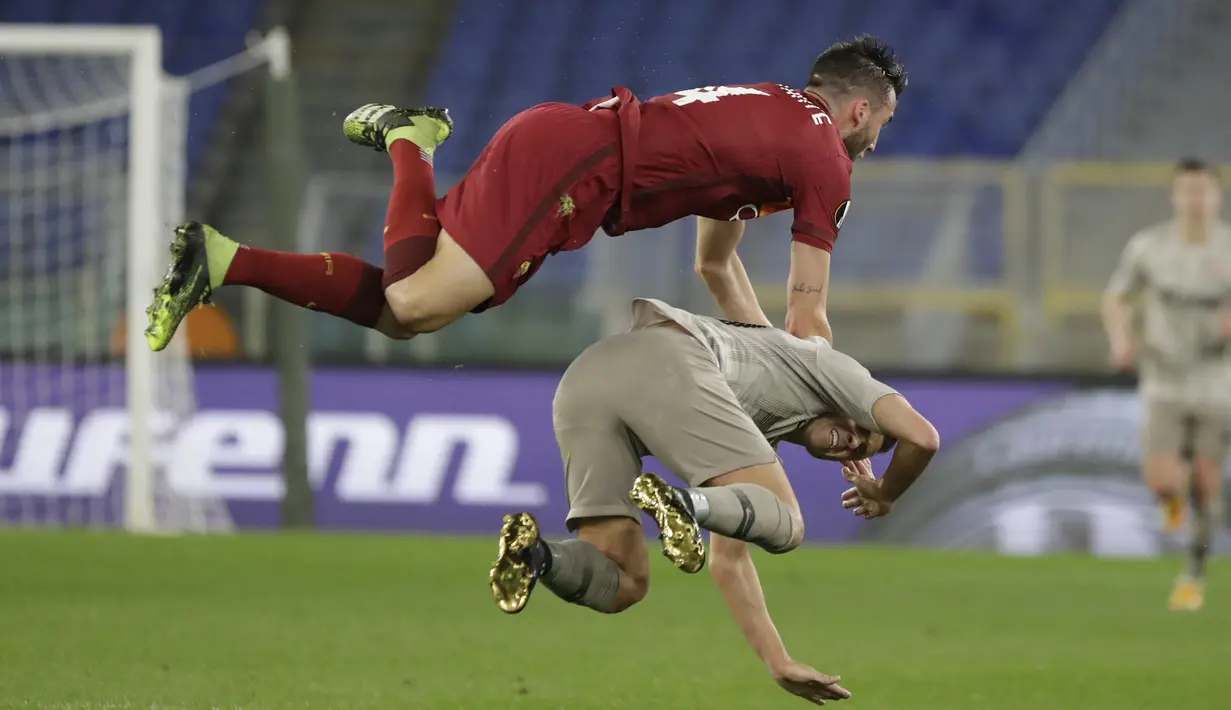 Gelandang AS Roma, Bryan Christante (atas) terbang usai berduel udara dengan striker Shakhtar Donetsk, Junior Moraes dalam laga leg pertama babak 16 besar Liga Europa 2020/2021 di Olimpico Stadium, Kamis (11/3/2021). AS Roma menang 3-0 atas Shakhtar Donetsk. (AP/Andrew Medichini)