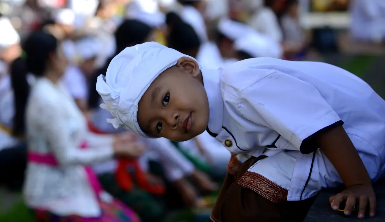 Seorang anak mengikuti hari raya Galungan di Pura Jagat Natha di Denpasar, Bali (1/11). Galungan dimaknai sebagai hari kemenangan Dharma (Kebaikan) melawan Adharma (Keburukan). (AFP Photo/Sonny Tumbelaka)
