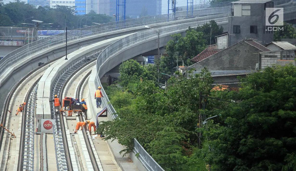 Pekerja menyelesaikan pembangunan LRT (Light Right Transit) Jabodebek di kawasan Kampung Makasar, Jakarta, Sabtu (26/10/2019). LRT akan diuji coba pada awal November 2019. (Liputan6.com/JohanTallo)