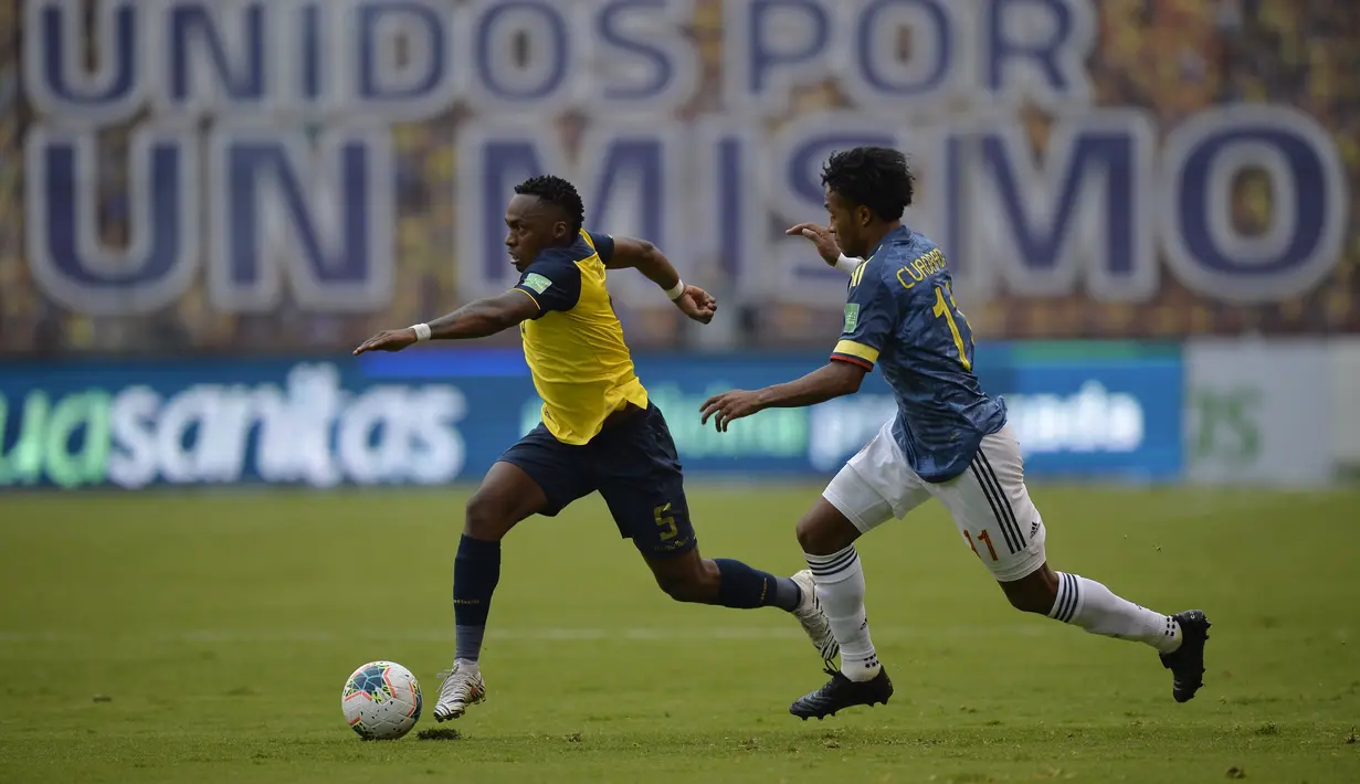 Gelandang Ekuador, Renato Ibarra membawa bola dari kejaran gelandang Kolombia, Juan Cuadrado pada pertandingan kualifikasi Piala Dunia 2022 di Quito, Ekuador, Selasa (17/11/2020). Ekuador menang telak atas Kolombia 6-1. (Rodrigo Buendia, Pool via AP)