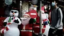 Seorang pria berjalan melewati dekorasi Natal yang dijual di sebuah pasar di Taipei, Taiwan (8/12/2021). Jelang Natal, warga Taipe yang merayakannya mulai berburu dekorasi dan pernak-pernik, dengan tujuan mempercantik rumah mereka saat perayaan 25 Desember 2021. mendatang. (AFP/Sam Yeh)
