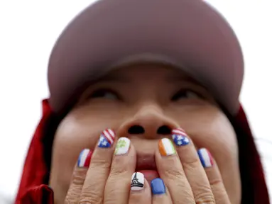 Warga tampak kagum menyaksikan acara pembukaan Olimpiade 2024 di Paris, Sabtu (27/7/2024). (AP Photo/Louise Delmotte)