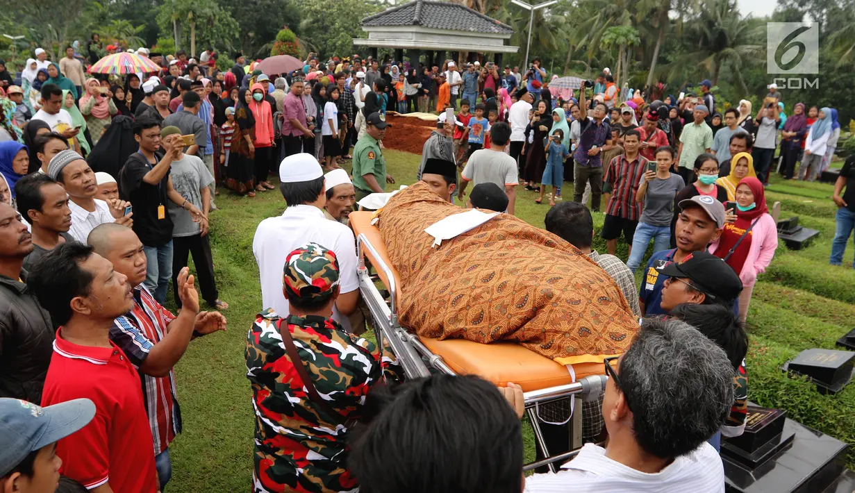 Warga menggotong jenazah korban kecelakaan Tanjakan Emen untuk dimakamkan di Tempat Pemakaman Umum (TPU) Legoso, Tangerang Selatan, Banten, Minggu (11/2). Ratusan keluarga dan kerabat turut hadir di pemakaman. (Liputan6.com/JohanTallo)